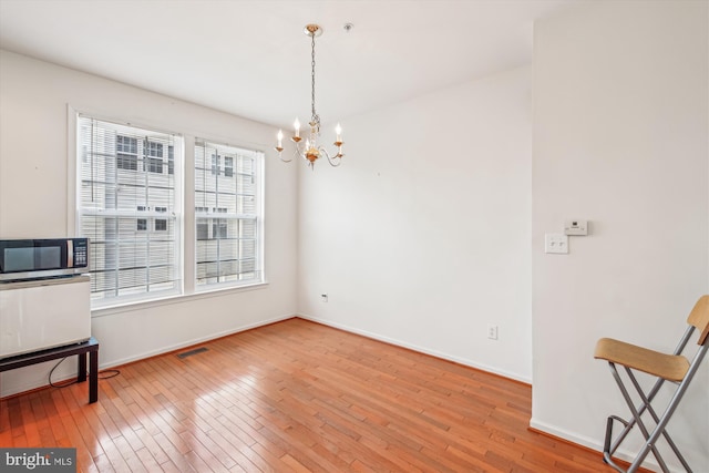 dining area with hardwood / wood-style flooring and a notable chandelier