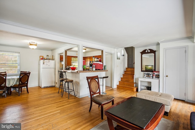 living room featuring light hardwood / wood-style flooring and ornamental molding