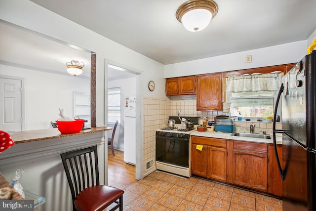 kitchen featuring decorative backsplash, white appliances, and sink