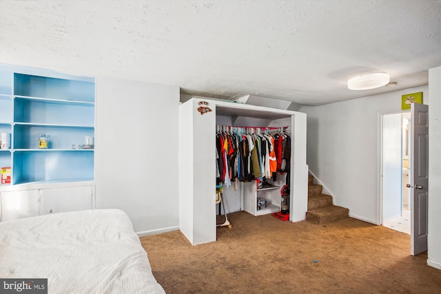 carpeted bedroom with a textured ceiling and a closet