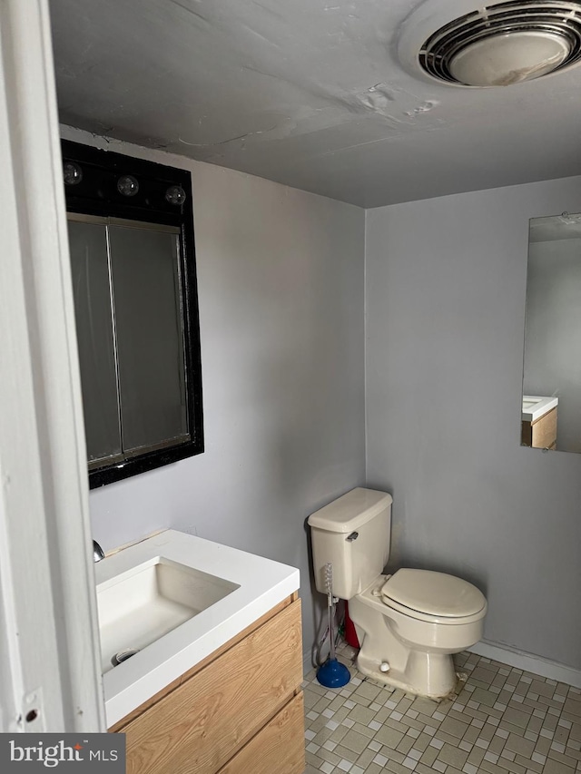 bathroom featuring toilet, vanity, and tile patterned floors