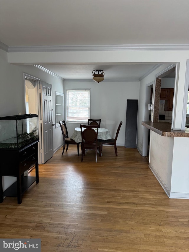 dining room featuring hardwood / wood-style floors and ornamental molding