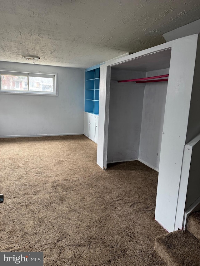 basement featuring carpet and a textured ceiling