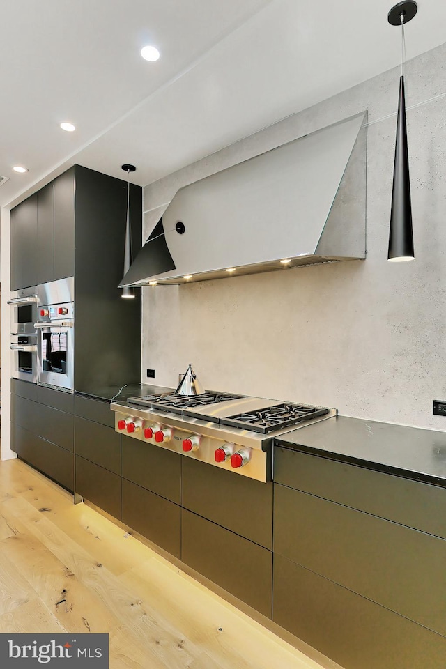 kitchen with decorative light fixtures, stainless steel gas cooktop, and light hardwood / wood-style flooring