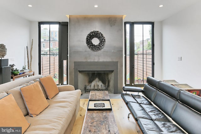 living room with plenty of natural light, light hardwood / wood-style floors, a fireplace, and expansive windows