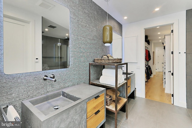 bathroom featuring hardwood / wood-style floors, tile walls, and sink