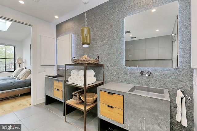 bathroom with hardwood / wood-style floors, vanity, a skylight, and tile walls