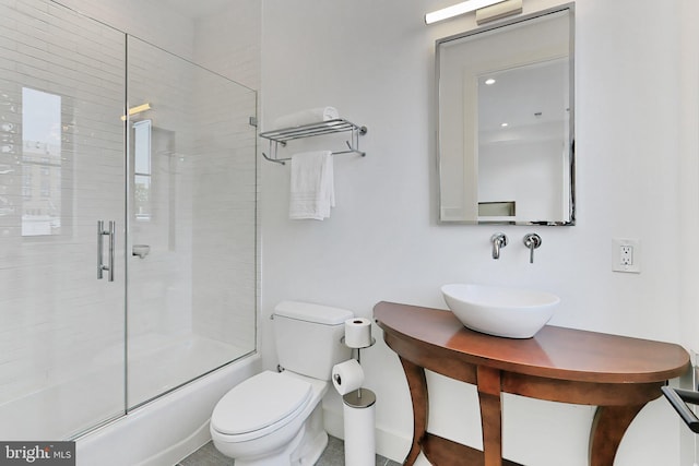 full bathroom featuring sink, enclosed tub / shower combo, and toilet