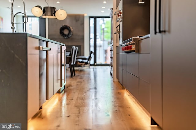 hall with expansive windows and light hardwood / wood-style floors