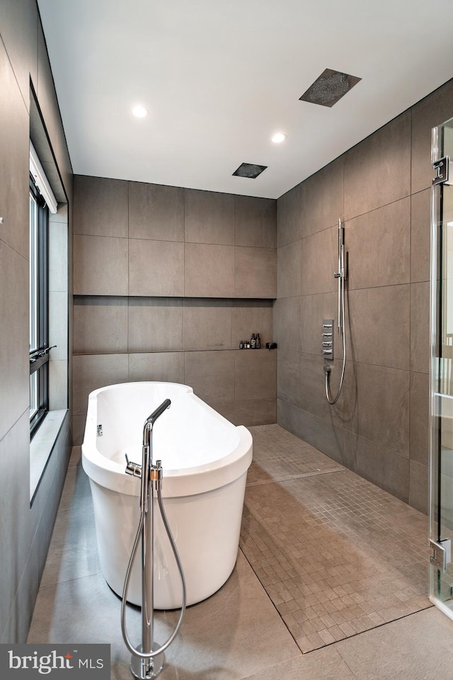 bathroom with separate shower and tub and tile walls