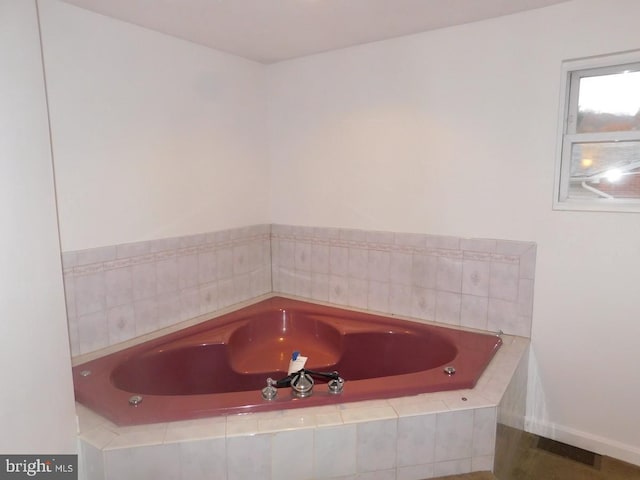 bathroom with a relaxing tiled tub