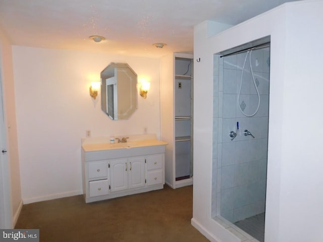 bathroom with vanity and a tile shower