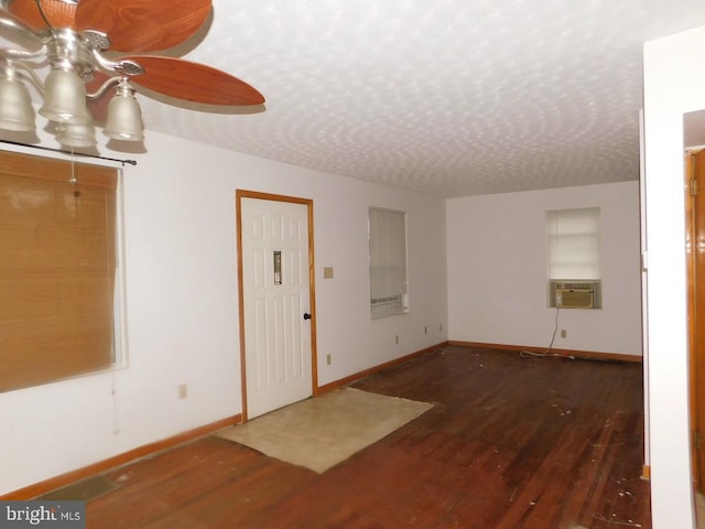 entrance foyer with a textured ceiling, cooling unit, dark wood-type flooring, and ceiling fan