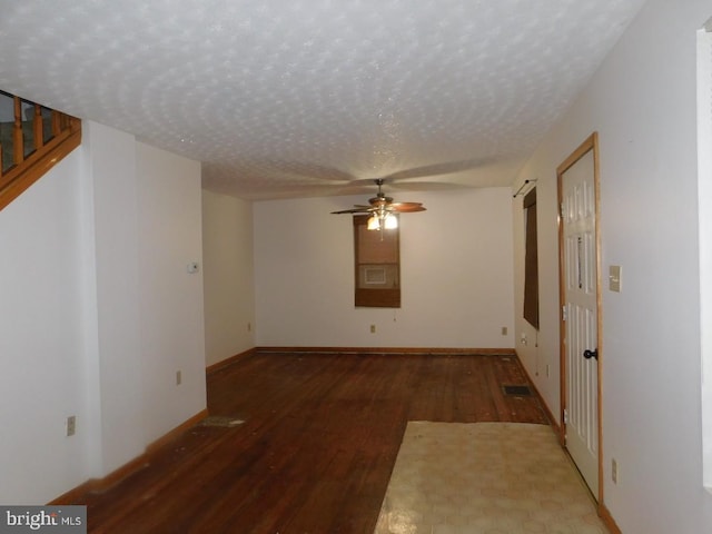 empty room with dark hardwood / wood-style flooring, a textured ceiling, and ceiling fan