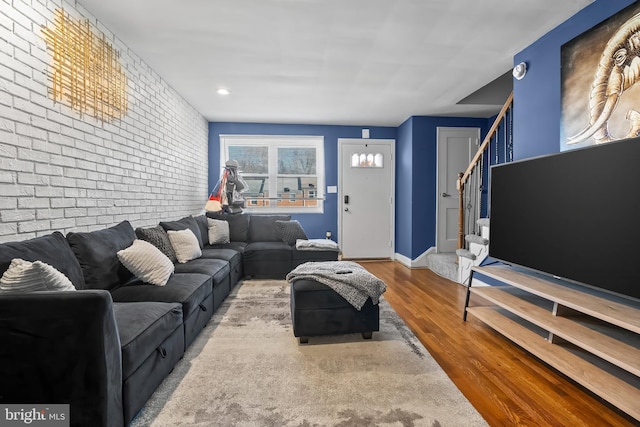 living room with wood-type flooring and brick wall