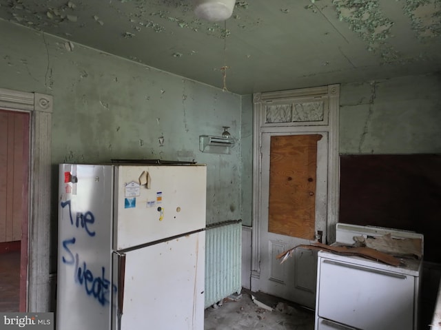 kitchen featuring radiator heating unit and white refrigerator