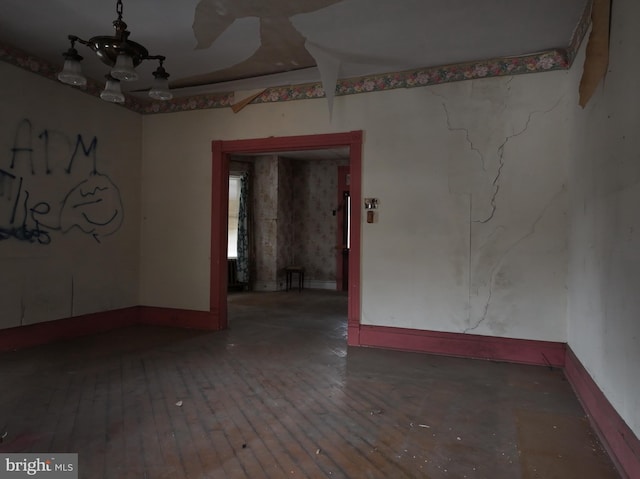 empty room featuring a chandelier and dark hardwood / wood-style floors