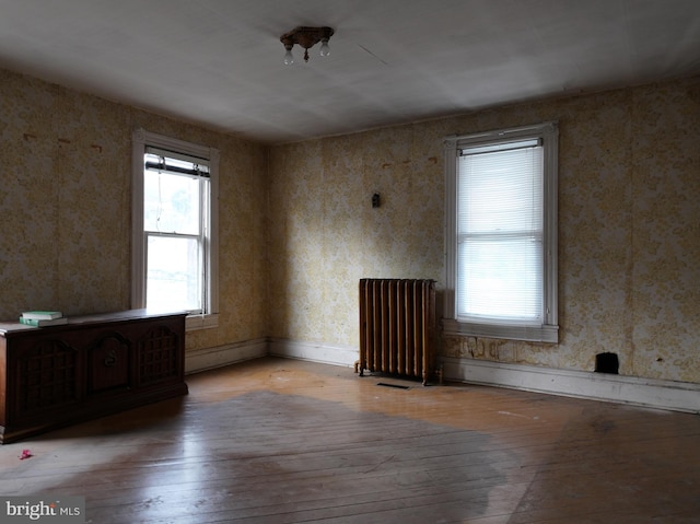 empty room featuring light hardwood / wood-style floors and radiator heating unit