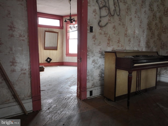 misc room featuring dark wood-type flooring and a notable chandelier