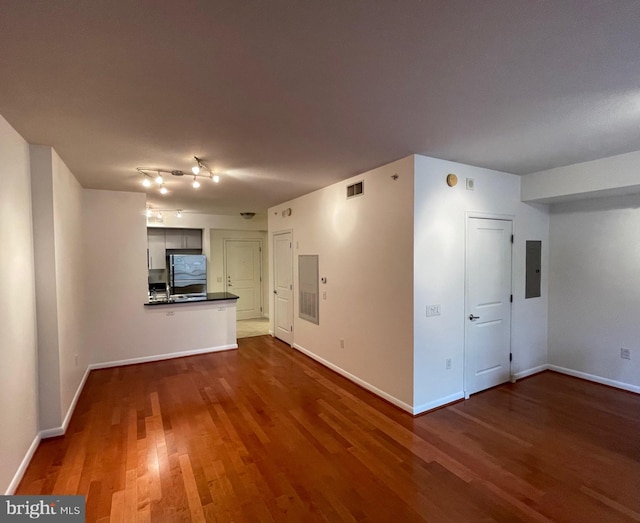 unfurnished living room with electric panel and hardwood / wood-style flooring