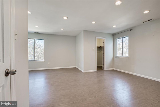 empty room with dark hardwood / wood-style flooring and a wealth of natural light