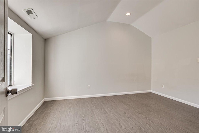 bonus room with wood-type flooring and vaulted ceiling