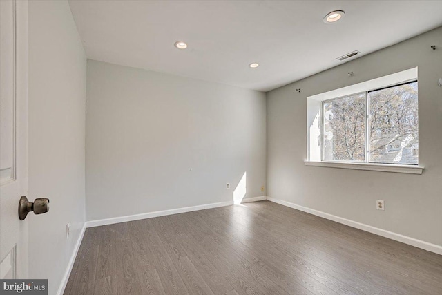 empty room with dark wood-type flooring and a healthy amount of sunlight