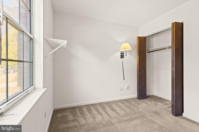 unfurnished bedroom with light carpet and a closet