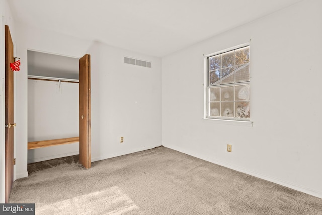 unfurnished bedroom featuring light carpet and a closet