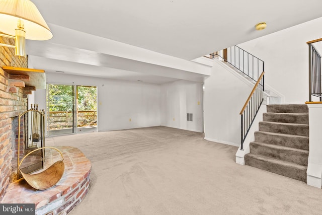 living room featuring carpet and a brick fireplace