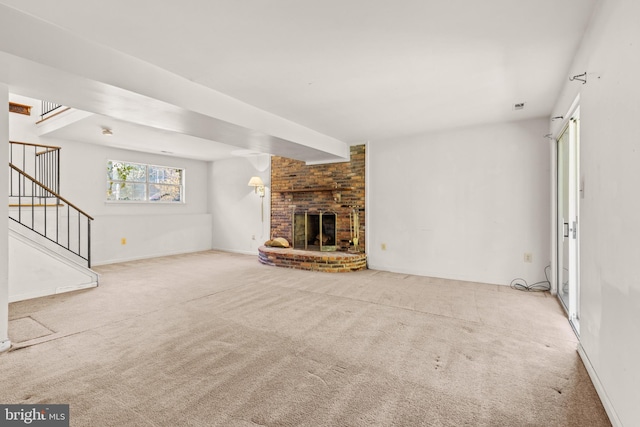 unfurnished living room featuring light carpet and a brick fireplace