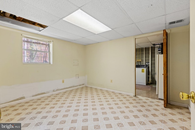 basement with a drop ceiling and washer / clothes dryer