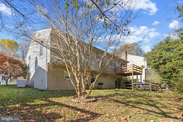 rear view of property featuring a yard and a deck