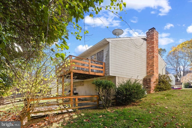 view of side of property with a balcony and a lawn