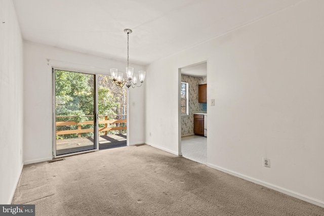 spare room featuring carpet flooring and a notable chandelier