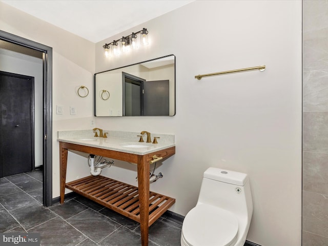 bathroom featuring double sink and toilet