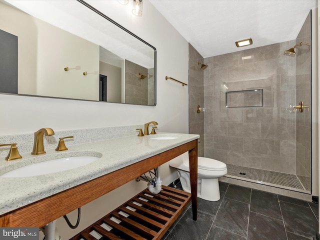 bathroom featuring toilet, sink, and a tile shower