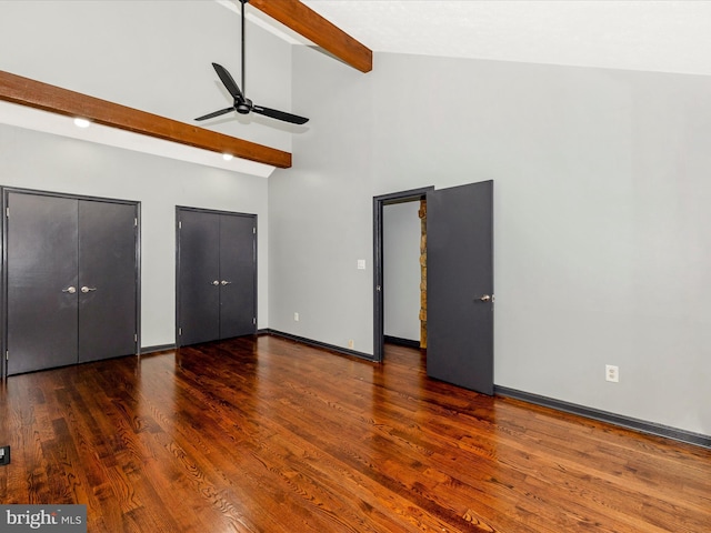 unfurnished bedroom featuring dark hardwood / wood-style flooring, ceiling fan, beam ceiling, high vaulted ceiling, and multiple closets