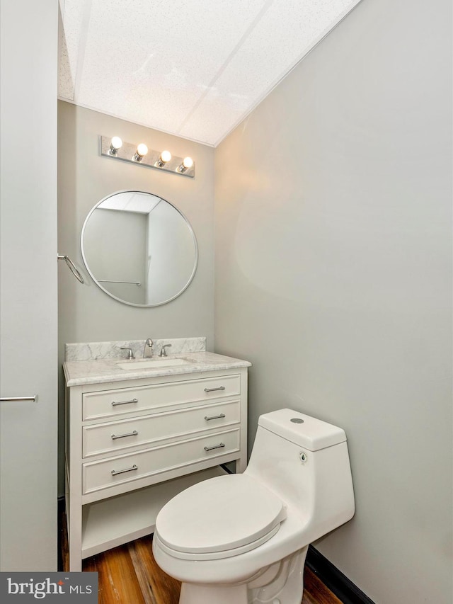 bathroom with hardwood / wood-style floors, vanity, and toilet