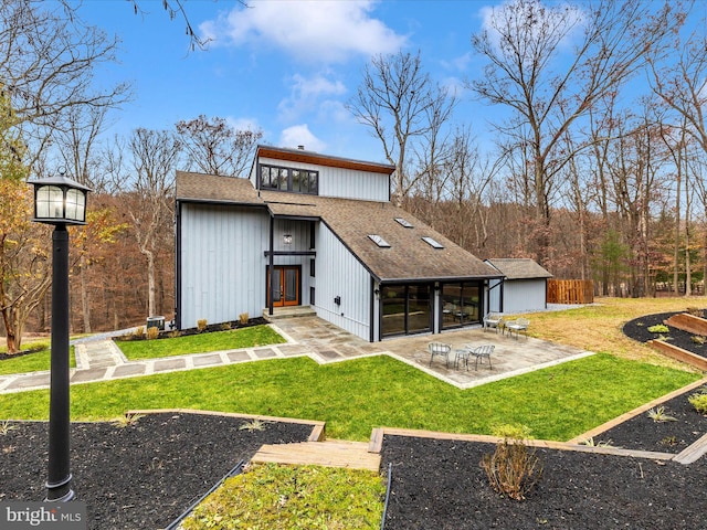 rear view of property featuring a lawn and a patio