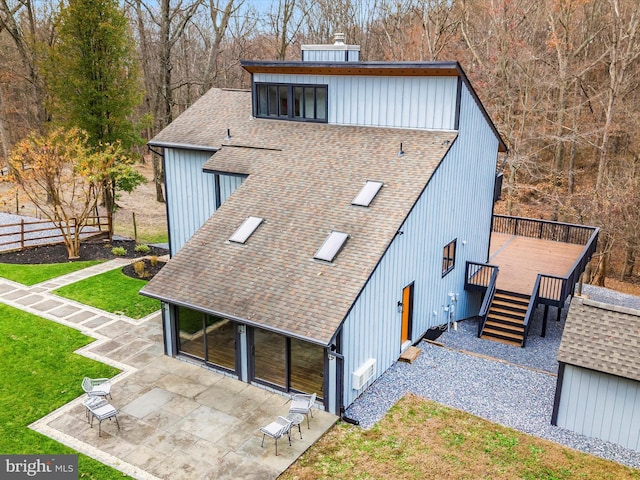 exterior space featuring a lawn, a wooden deck, and a patio