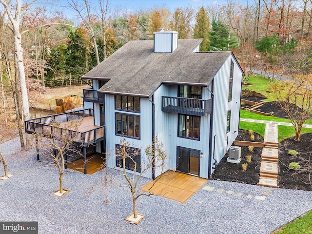 view of front of house with a balcony, central AC unit, and a deck