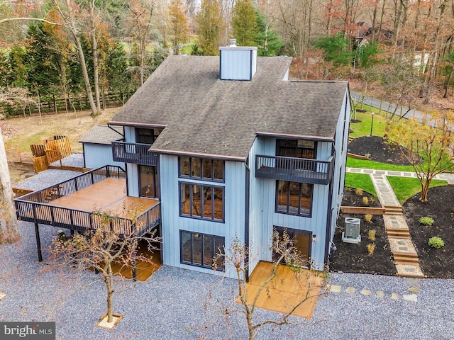 view of front of house featuring a garage, a balcony, and central AC