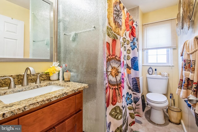 bathroom featuring curtained shower, toilet, and vanity