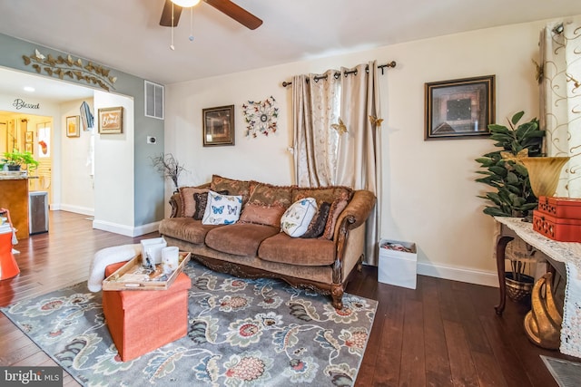 living room with ceiling fan and dark wood-type flooring