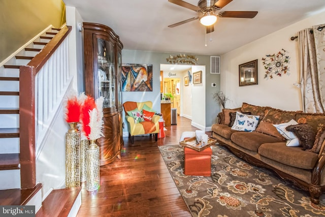 living room with ceiling fan and dark wood-type flooring