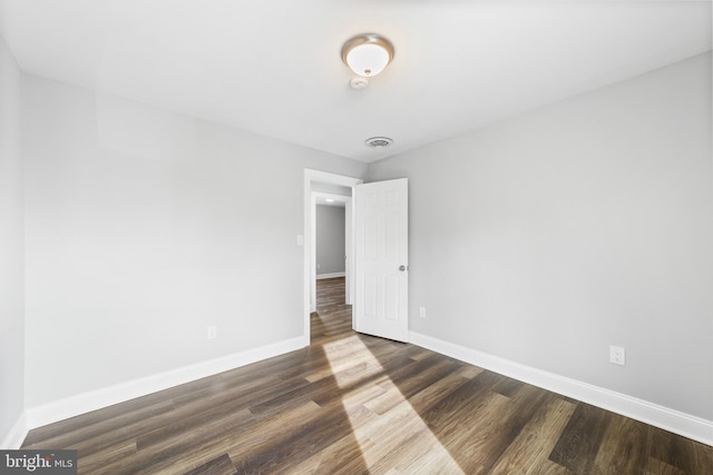 spare room with dark wood-type flooring