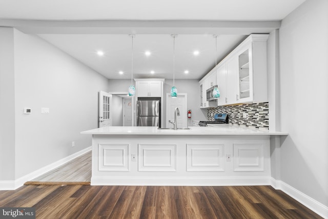 kitchen with white cabinets, hanging light fixtures, sink, appliances with stainless steel finishes, and kitchen peninsula