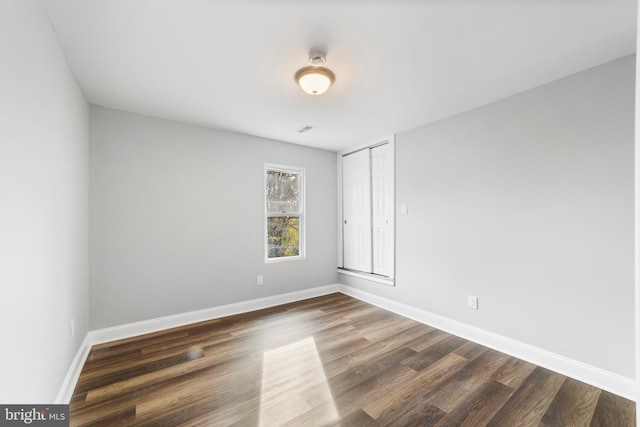 unfurnished room featuring dark wood-type flooring