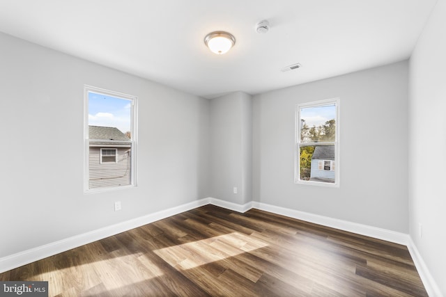 unfurnished room featuring dark hardwood / wood-style floors and a healthy amount of sunlight